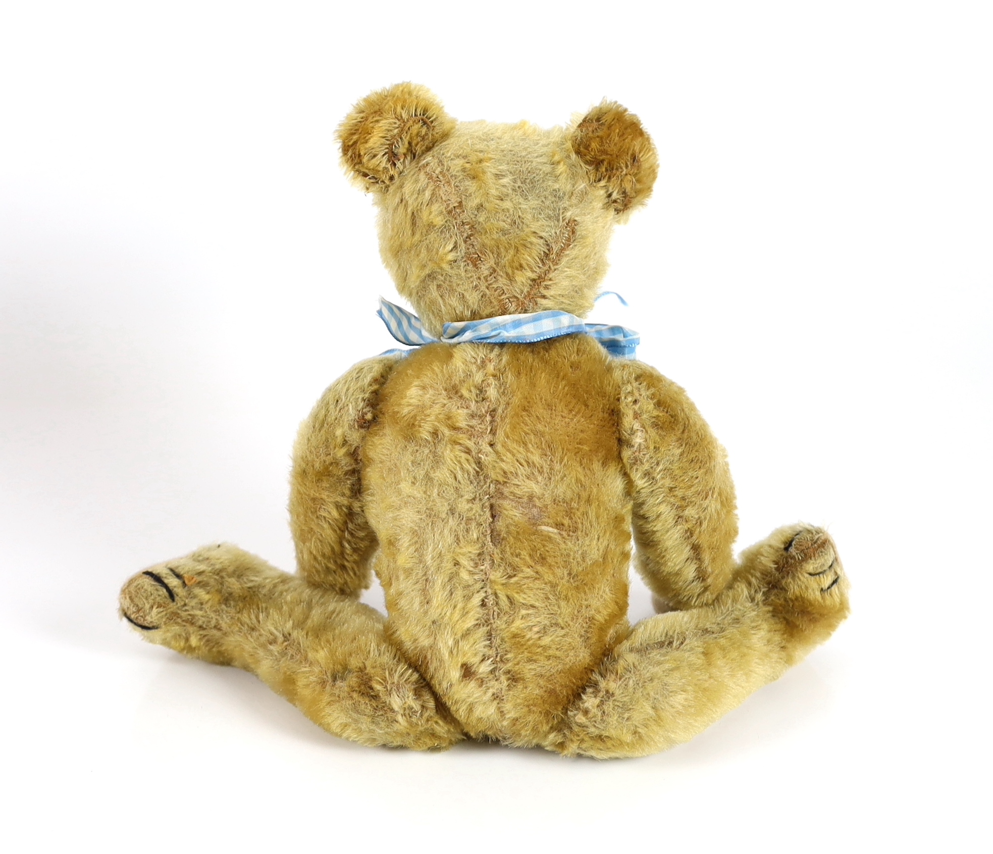 An early German bear, c.1920, with set in ears, black button eyes, 35cm, replaced paw pads, otherwise good condition